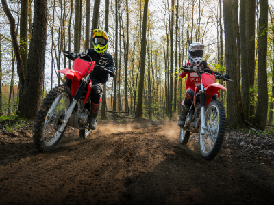 Deux coureurs sur Honda Trail Bikes dans les bois
