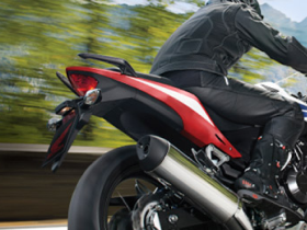 Un cavalier sur une moto Honda avec un fond flou d'arbres