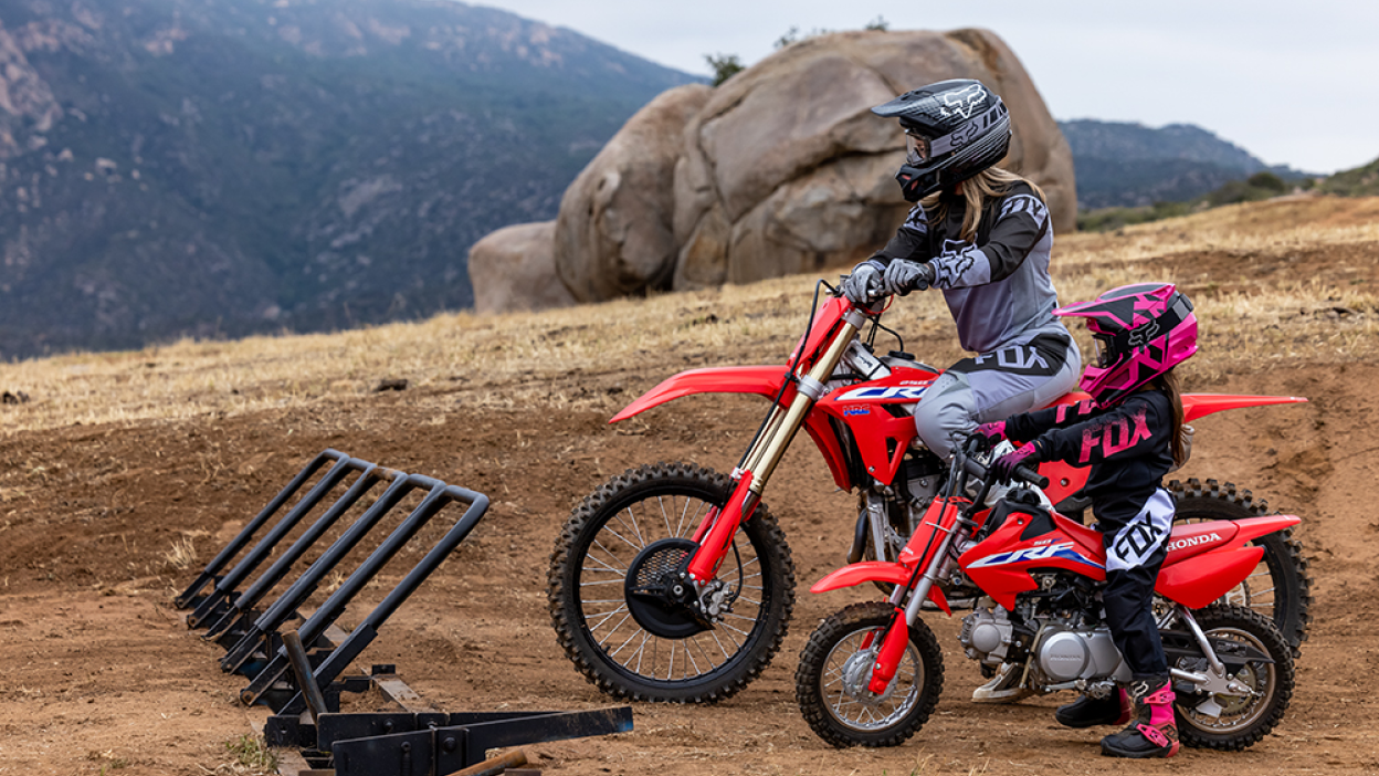 Deux coureurs se sont garés contre un rack avec leurs vélos Honda Trail