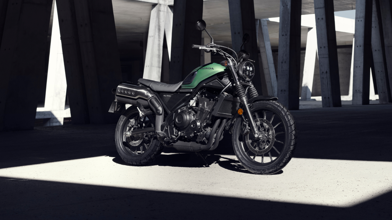 Une Honda SCL500 garée sous une structure en béton