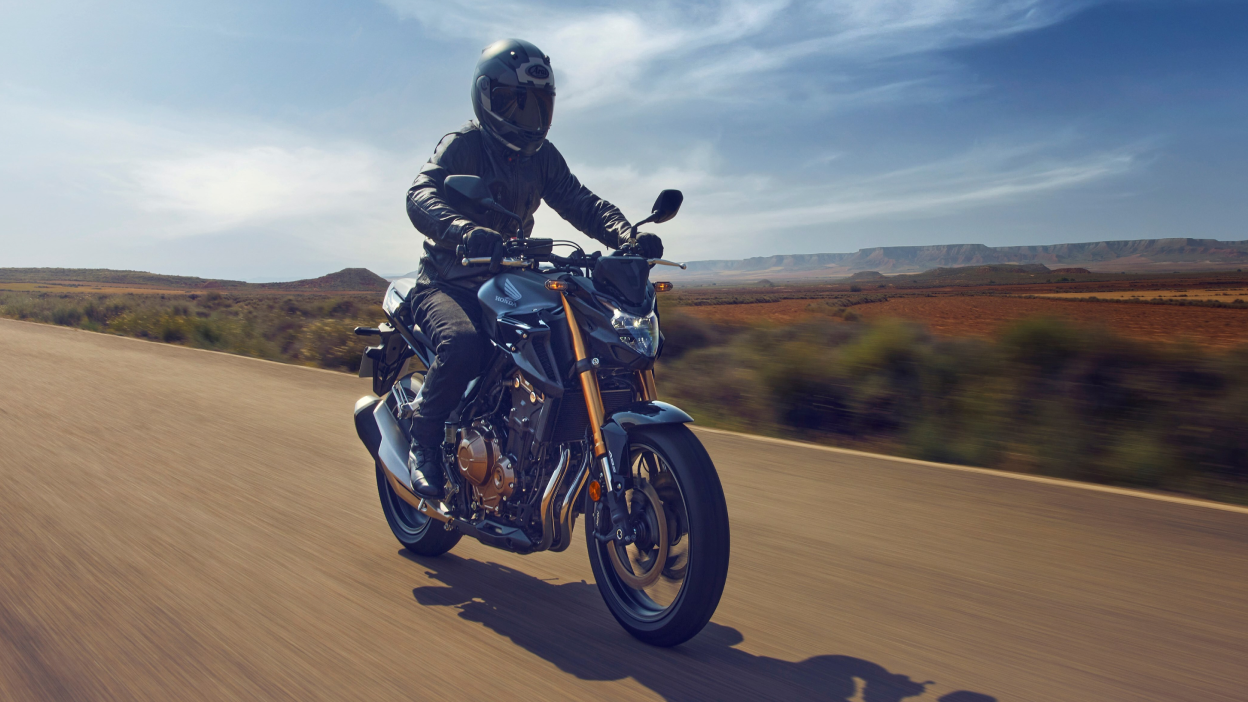 Une tête de coureur sur la conduite d'une moto Honda sur une route de campagne