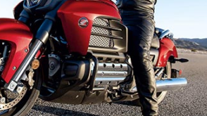 A biker sitting on a red motorcycle on a racetrack / Un motard assis sur une moto rouge sur une piste de course