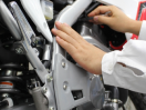 A person doing maintenace on a Honda /Une personne faisant le Maintenace sur une Honda