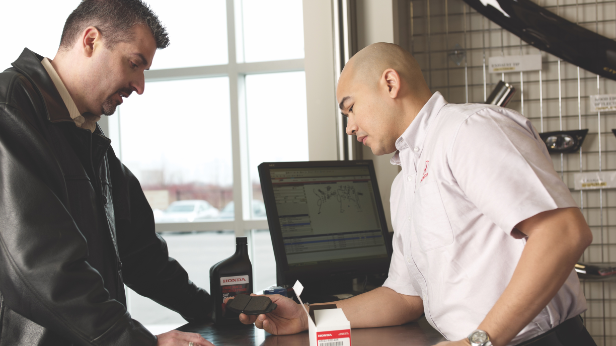 A Honda employee serving a customer/Un employé de Honda servant un client