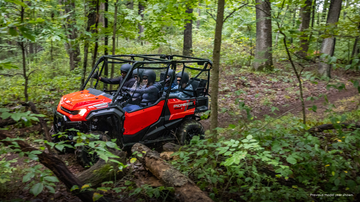 Riders in a Honda Pioneer at sunset