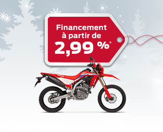 Une Honda CRF300L sur un dos d'hiver avec des flocons de neige avec une étiquette de cadeau rouge annonçant un taux d'intérêt de 2,99%